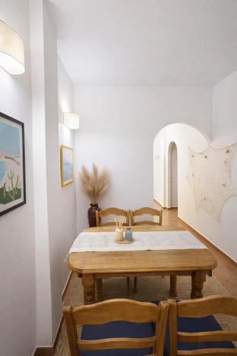 a dining room with a wooden table and chairs at Cala Rajá 5 in La Isleta del Moro