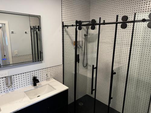 un bagno con doccia, lavandino e specchio di Xquisite Suites a Freeport