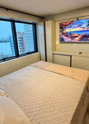 a bedroom with a large bed with two large windows at Estilo e Praticidade - Seu Flat ao lado do mar in São Luís