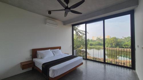 a bedroom with a bed and a large window at Stillwater Edge 2 - Level Two in Sri Jayewardenepura Kotte