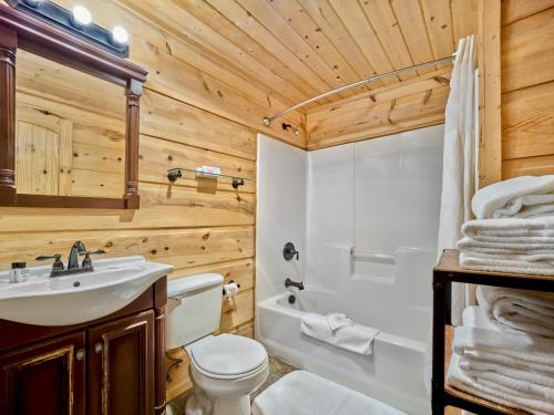 a bathroom with a toilet sink and a tub at Roosevelt Hotel & Cabins - Yellowstone in Gardiner