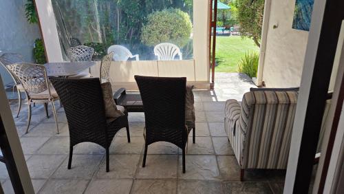 a patio with chairs and a table and a table and chairs at Hillcrest Cottage in Constantia