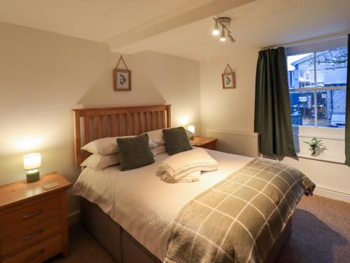 a bedroom with a bed with pillows and a window at 21 Entry Lane in Kendal