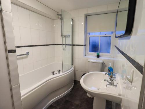 a bathroom with a tub and a sink and a toilet at 21 Entry Lane in Kendal