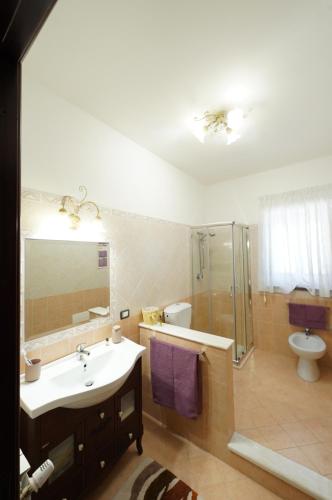 a bathroom with a sink and a shower and a toilet at Villino AL CASTAGNO in SantʼAlfio