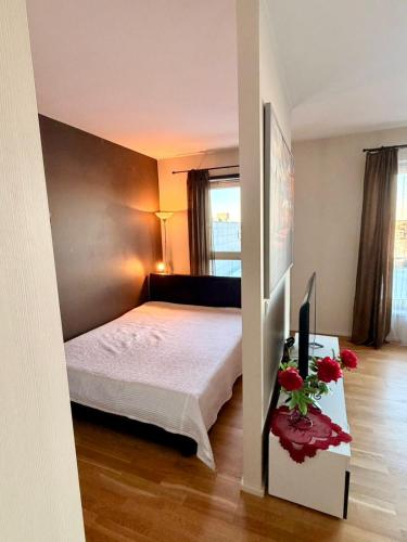 a bedroom with a bed and a table with flowers on it at Central Aida Apartment in Pärnu