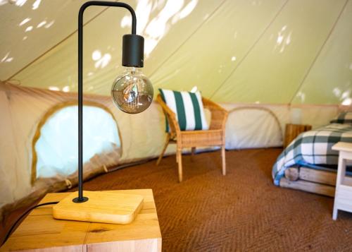 a lamp on a table in a tent at Orme nel parco - Villaggio Grechi in Tirivolo