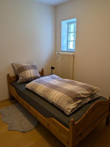 a bedroom with a wooden bed with a window at Ferienwohnung Bauernhofromantik in Raesfeld