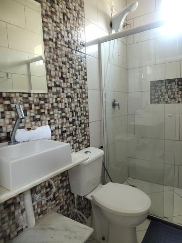 a bathroom with a toilet and a sink and a shower at Pousada Santa Adélia - Boipeba BA in Ilha de Boipeba