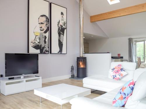 a living room with white furniture and a flat screen tv at Lovells Barn in Welland