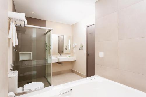 a bathroom with a shower and a toilet and a sink at Royal Palm Tower Anhanguera in Campinas