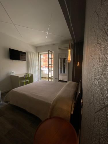 a bedroom with a large bed and a table at Albergo Ristorante Grace in Vibo Valentia