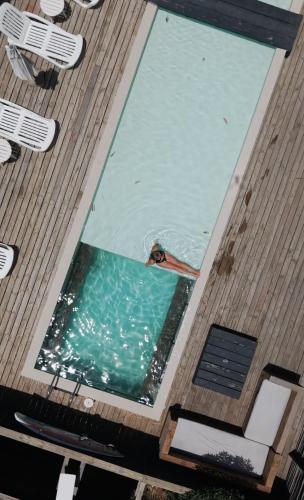 a person swimming in a pool on a deck at Surf Lodge Punta de Lobos in Pichilemu