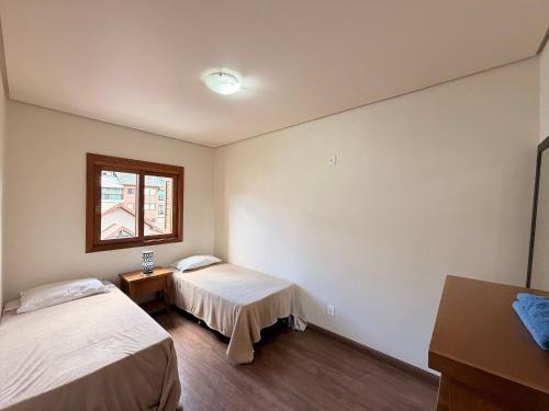 a room with two beds and a window at Apartamento Coração de Gramado in Gramado