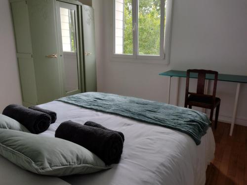 a bed in a room with a window and a chair at Gite des Noës in Lamballe Armor