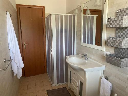 a bathroom with a sink and a mirror and a shower at Teresan Homestay in Mascali