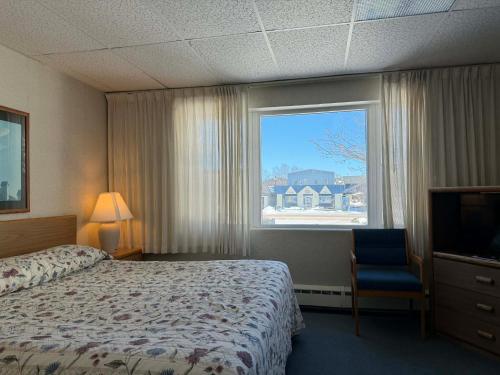 a hotel room with a bed and a window at The Shoreline Inn in Grand Marais