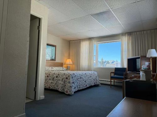 a hotel room with a bed and a television at The Shoreline Inn in Grand Marais