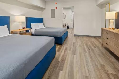a hotel room with two beds and a dresser at Seaport Suites in Wildwood