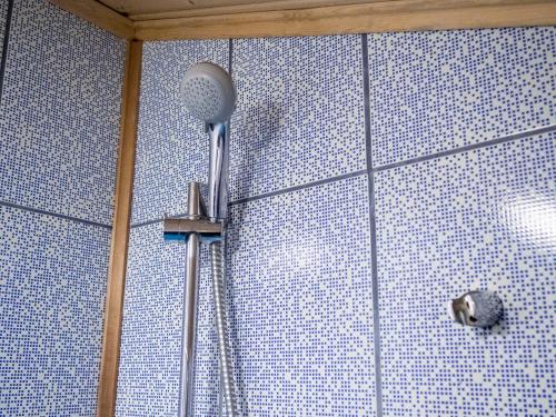 a shower with a shower head in a bathroom at Kätkävaara Wilderness Lodge in Muurola