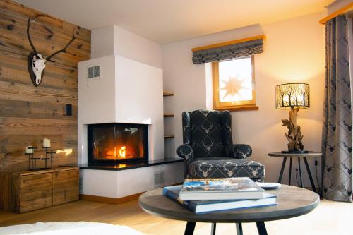a living room with a chair and a fireplace at Premium Apartment Grischuna 1-8 Pers in Klosters