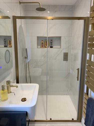 a white bathroom with a shower and a sink at Park View Guest Suite in South Milford