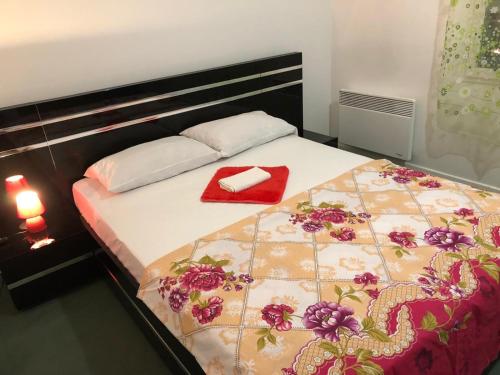 a bed with a red napkin on top of it at Disney golden house in Magny-le-Hongre