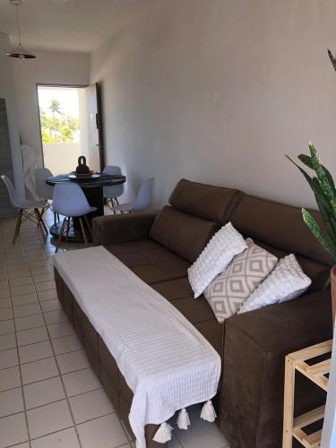 a living room with a brown couch and a table at Barrah flat in Barra de São Miguel