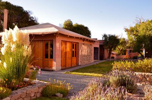 a small building with a garden in front of it at Las Marías Hotel Boutique in Tilcara