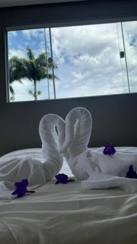 a white swan made out of towels on a bed at Cantinho dos Pássaros Centro Penedo RJ in Penedo
