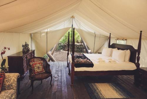 a bedroom with a bed in a tent at Fronterra Wellness Farm & Camp in Hillier