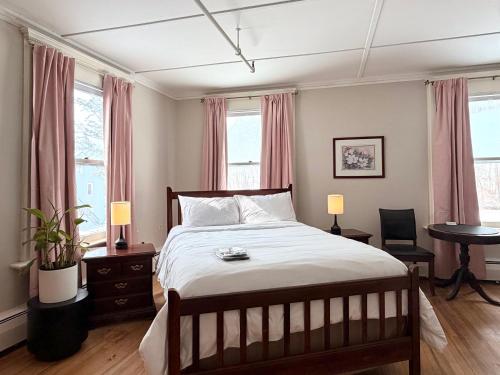 a bedroom with a bed and a table and windows at The Revival House in Adams