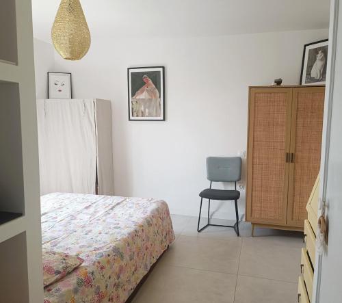 a bedroom with a bed and a chair in it at Location cocooning à Audenge in Audenge