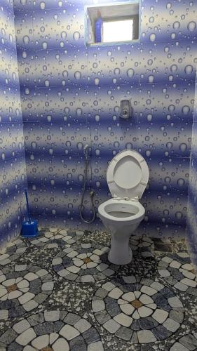 a bathroom with a toilet in a blue wall at Villa Estrela Holiday Escape in Betalbatim