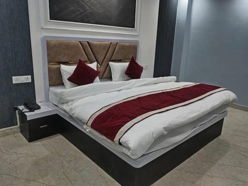a bedroom with a large bed with red pillows at Hotel KS GRAND in Mandhana