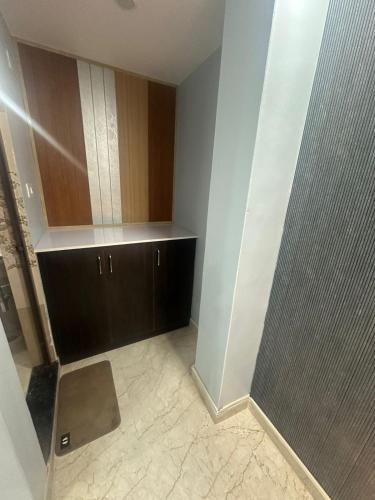 a bathroom with a shower and a brown cabinet at Hotel KS GRAND in Mandhana