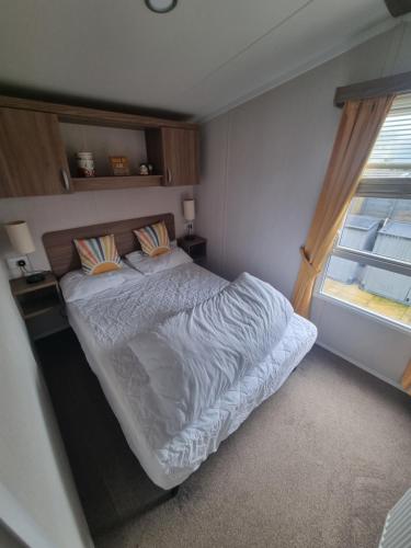 a bedroom with a bed and a window at 1 minute walk to the beach here! 37 Unity Beach Brightholme Brean sleeps 6 Pet friendly Pets stay free in Brean
