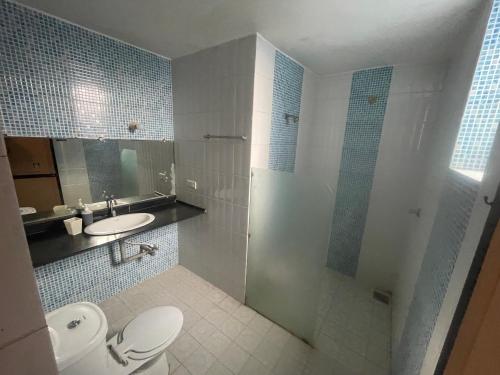 a bathroom with a toilet and a sink and a shower at Vista Maria Guesthouse in Dona Paula