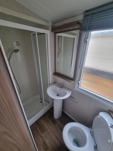 a bathroom with a toilet and a sink and a shower at 1 minute walk to the beach here! 37 Unity Beach Brightholme Brean sleeps 6 Pet friendly Pets stay free in Brean