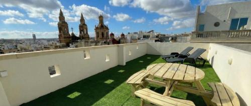 a patio with a table and chairs on a roof at Sliema Cozy Townhouse with Rooftop View, Prime Spot in Sliema