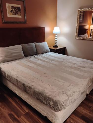 a bedroom with a large bed with a wooden floor at Gated 1 King Bedroom 1 Bath Apt with Full Kitchen 129 in Baton Rouge