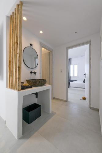 a white bathroom with a sink and a mirror at Anemomylos in Kastraki