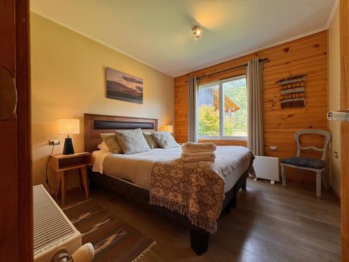 a bedroom with a large bed and a window at Vuelta al Sur in Puelo