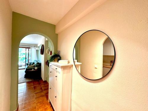 a room with a mirror on a wall with a dresser at La Palmera Suite Calpe in Calpe