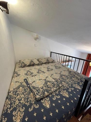 a bedroom with a bed with a blanket on it at Sweet home with a jard Slavica in Šušanj