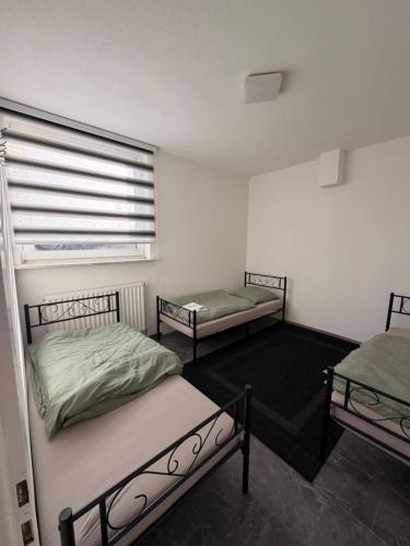 two beds in a room with a window at A2 MonteurQuatier Lünen in Lünen