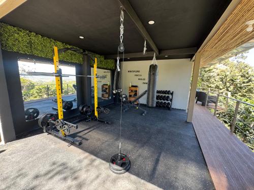 a gym with a bunch of equipment in a house at Roca Verde Retreats & Car Rental in Atenas