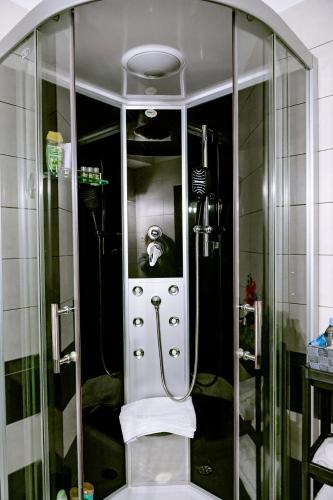 a shower with a glass door in a bathroom at New Airport Apartment in Sibiu