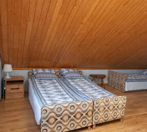 a bed in a room with a wooden ceiling at Agroturystyka uDuraja in Kiczora