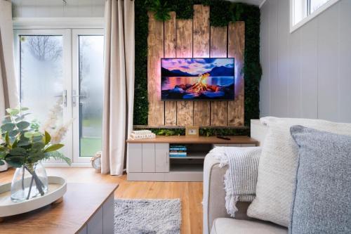a living room with a tv on a wooden wall at Silverdale Lodge, HotTub, Wi-FI, Quiet & Sleeps 4 in Warton